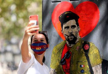 A woman takes a selfie with a mural of Lionel Messi dressed as Che Guevara as FC Barcelona's squad arrive for coronavirus disease (COVID-19) test, ahead of the resumption of training on August 31, in Barcelona, Spain August 30, 2020.