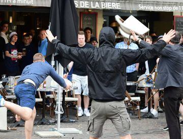 A Russian football supporter lobs a chair towards England fans sitting in a cafe in the northern city of Lille on June 14, 2016, three days after Russian and England supporters clashed in Marseille.