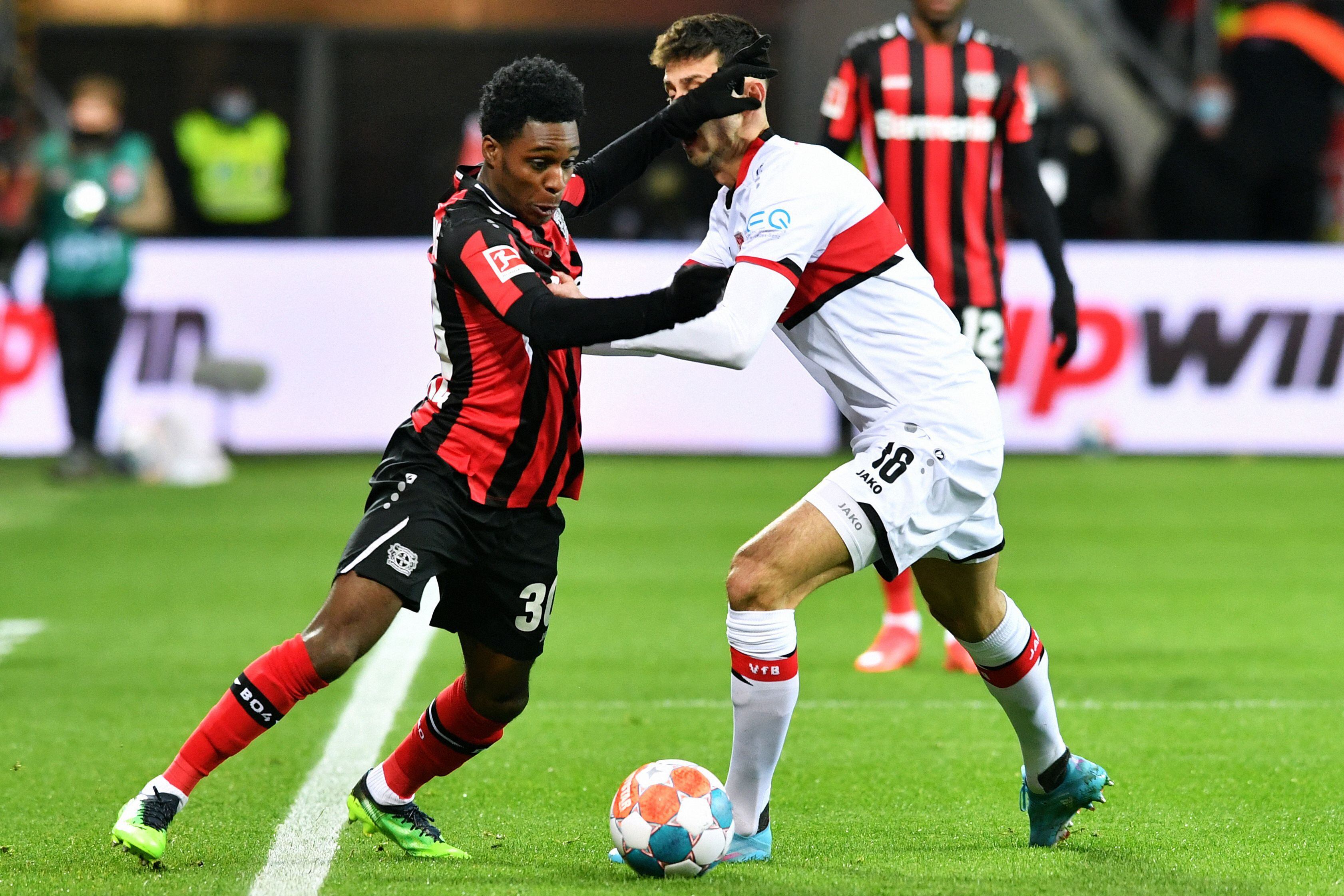 Leverkusen's Dutch defender Jeremie Frimpong (L) and Stuttgarts's Portuguese forward Tiago Tomas vie for the ball during the German first division Bundesliga football match Bayer 04 Leverkusen v VfB Stuttgart in Leverkusen on February 12, 2022. (Photo by UWE KRAFT / AFP) / DFL REGULATIONS PROHIBIT ANY USE OF PHOTOGRAPHS AS IMAGE SEQUENCES AND/OR QUASI-VIDEO
