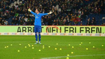 Los aficionados arrojan pelotas de tenis durante un partido de la Bundesliga.