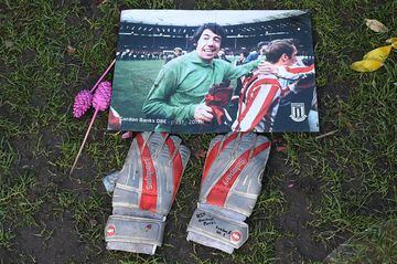 A photograph of Stoke City and England's former goalkeeper Gordon Banks is pictured next to a pair of goalkeeper's gloves amid floral tributes to honour England's World Cup winning goalkeeper.