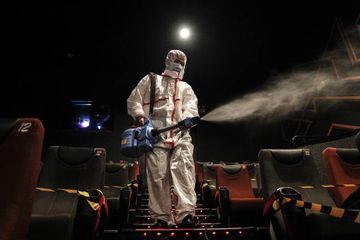 Employees wear protective clothing to disinfect a cinema in Wuhan on July 20, 2020.