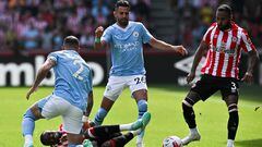 Manchester City's English defender Kyle Walker (L) fouls Brentford's Nigerian midfielder Frank Onyeka (bottom) next to Manchester City's Algerian midfielder Riyad Mahrez (back C) and Brentford's English defender Rico Henry (R) during the English Premier League football match between Brentford and Manchester City at Gtech Community Stadium in London on May 28, 2023. (Photo by Ben Stansall / AFP) / RESTRICTED TO EDITORIAL USE. No use with unauthorized audio, video, data, fixture lists, club/league logos or 'live' services. Online in-match use limited to 120 images. An additional 40 images may be used in extra time. No video emulation. Social media in-match use limited to 120 images. An additional 40 images may be used in extra time. No use in betting publications, games or single club/league/player publications. / 