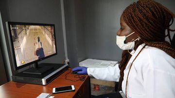 A health official screens a passenger inside the departure terminal of the Nnamdi Azikiwe International Airport, in Abuja, Nigeria on September 7, 2020. - After a five-month closure of the Nigerian airspace due to the COVID-19 coronavirus pandemic, flight
