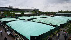 Varias pistas de Wimbledon cubiertas con lonas para protegerlas de la lluvia.
