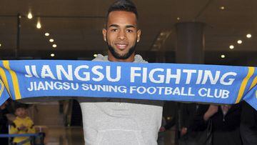 Brazilian striker Alex Teixeira poses for photos upon his arrival at the airport in Nanjing in eastern China&#039;s Jiangsu province.