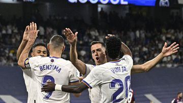 Real Madrid's players celebrate their fifth goal scored by Brazilian forward Vinicius Junior during the Spanish league football match between Real Madrid CF and Levante UD at the Santiago Bernabeu stadium in Madrid on May 12, 2022. (Photo by JAVIER SORIAN