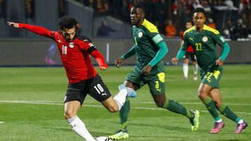 Egypt&#039;s forward Mohamed Salah shoots to open the scoring during the 2022 Qatar World Cup African Qualifiers football match between Egypt and Senegal at Cairo International Stadium in the Egyptian capital on March 25, 2022. (Photo by Khaled DESOUKI / 