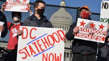 (FILES) In this file photo activists hold signs as they take part in a rally in support of DC statehood near the US Capitol in Washington, DC on March 22, 2021. - The House of Representatives voted on April 22, 2021 to make the US capital Washington the n