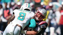 MIAMI GARDENS, FLORIDA - SEPTEMBER 11: Mac Jones #10 of the New England Patriots takes a hit from Jevon Holland #8 of the Miami Dolphins after making a pass in the fourth quarter of the game at Hard Rock Stadium on September 11, 2022 in Miami Gardens, Florida.   Eric Espada/Getty Images/AFP