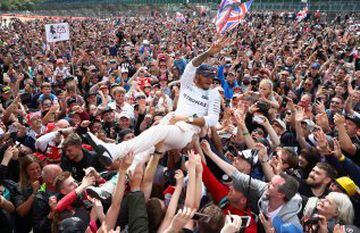 El piloto británico Lewis Hamilton surfea entre cientos de aficionados tras ganar en el GP de casa, Gran Bretaña.