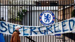 A pedestrian walks past an anti-European Super League banner reading &quot;Supergreed&quot; outside an entrance to Stamford Bridge football stadium in London on April 20, 2021, ahead of the English Premier League match between Chelsea and Brighton and Hov