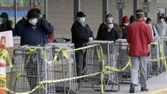 Las personas usan una m&aacute;scara mientras esperan a una distancia segura para ingresar a un supermercado, el lunes 20 de abril de 2020, en Chelsea, Massachusetts.