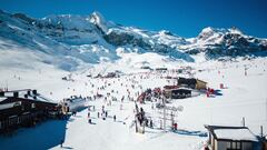 La estación de esquí de Candanchú, con esquiadores y nieve, en un día soleado.