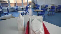 Mascarillas y gel desinfectante en la mesa del profesor de un aula del colegio Virgen de Europa en Boadilla del Monte