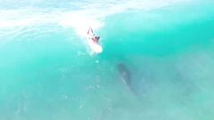 Un surfista realizando el take off en una ola mientras debajo suyo pasa un tibur&oacute;n de 3 metros en Haw&aacute;i (Estados Unidos), en octubre del 2022. 