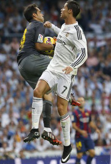 El portero chileno del FC Barcelona Claudio Bravo (i) detiene el balón ante el delantero portugués del Real Madrid Cristiano Ronaldo (d). 