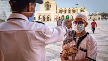 A mask-clad worker measures the body temperature of incoming Muslim worshippers (COVID-19 coronavirus pandemic precaution) arriving for prayers at the Hasan II mosque, one of the largest in the African continent, in Morocco&#039;s Casablanca on June 16, 2