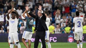 Real Madrid's Italian coach Carlo Ancelotti (C), Real Madrid's Brazilian forward Vinicius Junior (L) and teammates acknowledge the crowd at the end of the Spanish league football match between Real Madrid CF and Real Betis at the Santiago Bernabeu stadium in Madrid on May 20, 2022. (Photo by Pierre-Philippe MARCOU / AFP)