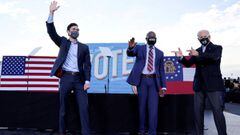 FILE PHOTO: President-elect Joe Biden points to Democratic Senate candidates from Georgia Jon Ossoff &amp;nbsp;and Raphael Warnock, as he campaigns on their behalf ahead of their January 5 run-off elections, during a drive-in campaign rally in Atlanta, Ge
