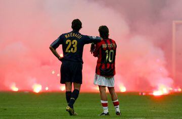 A 2005 Milan derby was halted for a time after fans hurled flares all over the pitch. This picture of opponents Rui Costa and Marco Materazzi quickly became a hit in newspapers across the world.