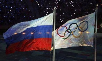 The Russian and Olympics flags fly side by side at the Sochi Olympics in 2014