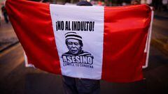 A woman holds a Peruvian flag that reads "No pardon, murderer serve your sentence" after Peru's top court reinstated a controversial pardon for Peru's former President Alberto Fujimori who had been sentenced for human rights violations, in Lima, Peru March 19, 2022. REUTERS/Sebastian Castaneda
