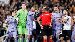 Los jugadores del Real Madrid protestan al árbitro del encuentro, Gil Manzano, tras la decisión de anular el gol a Jude Bellingham. En la imagen, el colegiado se lleva la  mano al bolsillo para sacar la tarjeta roja al jugador inglés.