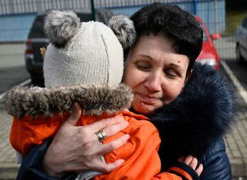A visibly emotional Ukrainian woman hugs a baby after crossing the border from Ukraine into Slovakia, into the city of Ubla.