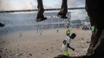 Somali people play football in the smoky air due to burning litters at the destroyed and abandoned secondary school since 1991, in Mogadishu, Somalia, on June 7, 2018.
 Playing football, nothing could be simpler. Around the world and whatever the landscape. Perched on top of an Asian skyscraper, lost on a dusty trail in the middle of the majestic mountains of Nepal or nestled at the foot of an ancient aqueduct in Rome, the pitch takes on many forms and is adapted to its environment. / AFP PHOTO / Mohamed ABDIWAHAB