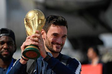 France's goalkeeper Hugo Lloris smiles as he holds the trophy as he celebrates with teammates upon their arrival at the Roissy-Charles de Gaulle airport on the outskirts of Paris, on July 16, 2018 after winning the Russia 2018 World Cup final football mat