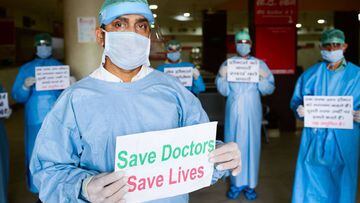Doctors and medical staff of Narayan Swaroop Hospital hold placards to protest against the recent assaults on health workers in different parts of the country during a nationwide lockdown imposed as a preventive measure against the spread of the COVID-19 