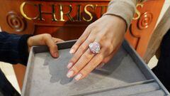 An employee poses with a 15.81 carat fancy vivid purple pink diamond ring, which is called The Sakura Diamond, during a preview at Christie&rsquo;s ahead of the upcoming auction, in Hong Kong, China May 6, 2021. REUTERS/Joyce Zhou