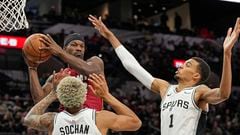 Miami Heat forward Jimmy Butler (22) looks to pass the ball while defended by San Antonio Spurs forwards Victor Wembanyama (1) and Jeremy Sochan (10) at Frost Bank Center.