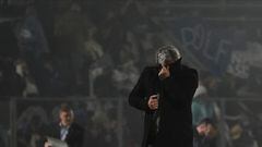Coach Nestor Gorosito, of Gimnasia y Esgrima La Plata, protects himself from tear gas during the match between Gimnasia y Esgrima La Plata and Boca Juniors in the Liga Profesional 2022, before it was suspended due clashes between supporters and the police outside the stadium, at Juan Carmelo Zerillo Stadium, in La Plata, Argentina October 6, 2022. REUTERS/Jose Brusco NO RESALES. NO ARCHIVES