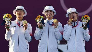 25 July 2021, Japan, Tokyo: South Korea&#039;s An San, Jang Minhee, Kang Chaeyoung celebrate with their gold medals on the podium during the medal ceremony of the women&#039;s team archery event at Yumenoshima Park Archery Field during the Tokyo 2020 Olym