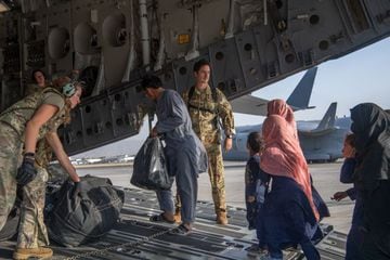 U.S. Air Force loadmasters and pilots load passengers aboard a U.S. Air Force C-17 Globemaster III in support of the Afghanistan evacuation at Kabul Airport