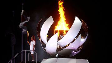 Naomi Osaka of Japan holds the Olympic torch after lighting the cauldron at the Tokyo 2020 Olympics opening ceremony, July 23, 2021.