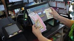 CALIFORNIA, USA - NOVEMBER 7: A cashier holds Powerball lottery tickets at a 7-Eleven store in Milpitas, California, United States on November 7, 2022. Today's Powerball jackpot hits a record $1.9 billion. The largest Powerball jackpot ever won was in January 2016 when three winners split a prize advertised at $1.586 billion. (Photo by Tayfun Coskun/Anadolu Agency via Getty Images)