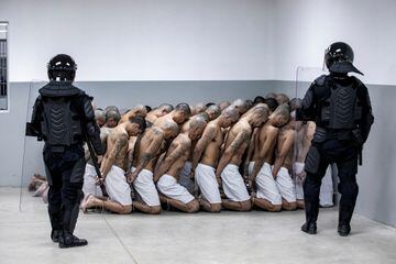 Agentes del Centro de Confinamiento del Terrorismo custodian a un grupo de prisioneros.