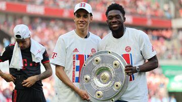 Cologne (Germany), 27/05/2023.- Bayern Munich's Jamal Musiala (L) and Alphonso Davies (R) pose with the league title trophy after winning the German Bundesliga soccer match between 1.FC Cologne and FC Bayern Munich, in Cologne, Germany, 27 May 2023. Bayern Munich won the title due to a better goal difference. (Alemania, Colonia) EFE/EPA/ANNA SZILAGYI CONDITIONS - ATTENTION: The DFL regulations prohibit any use of photographs as image sequences and/or quasi-video.
