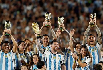 Lionel Messi and his teammates celebrate with their families and World Cup trophies after the match.