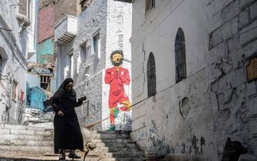 An Egyptian woman walks past a mural of Egyptian footballer Mohamed Salah in ciaro on June 17, 2019, four days ahead of the African Cup of Nations debut (CAN). (Photo by Khaled DESOUKI / AFP)