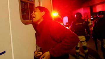 En la imagen, Viangly, una migrante venezolana, llora junto a la ambulancia que transporta a su esposo.