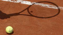 Sombra de una raqueta sobre una pista de tenis.