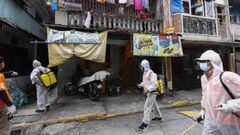 Manila (Philippines), 03/08/2020.- City workers in protective suits go around disinfecting streets as residents look out from their apartment at a village in Caloocan City, Metro Manila, Philippines 03 August 2020. Philippine President Rodrigo Duterte app