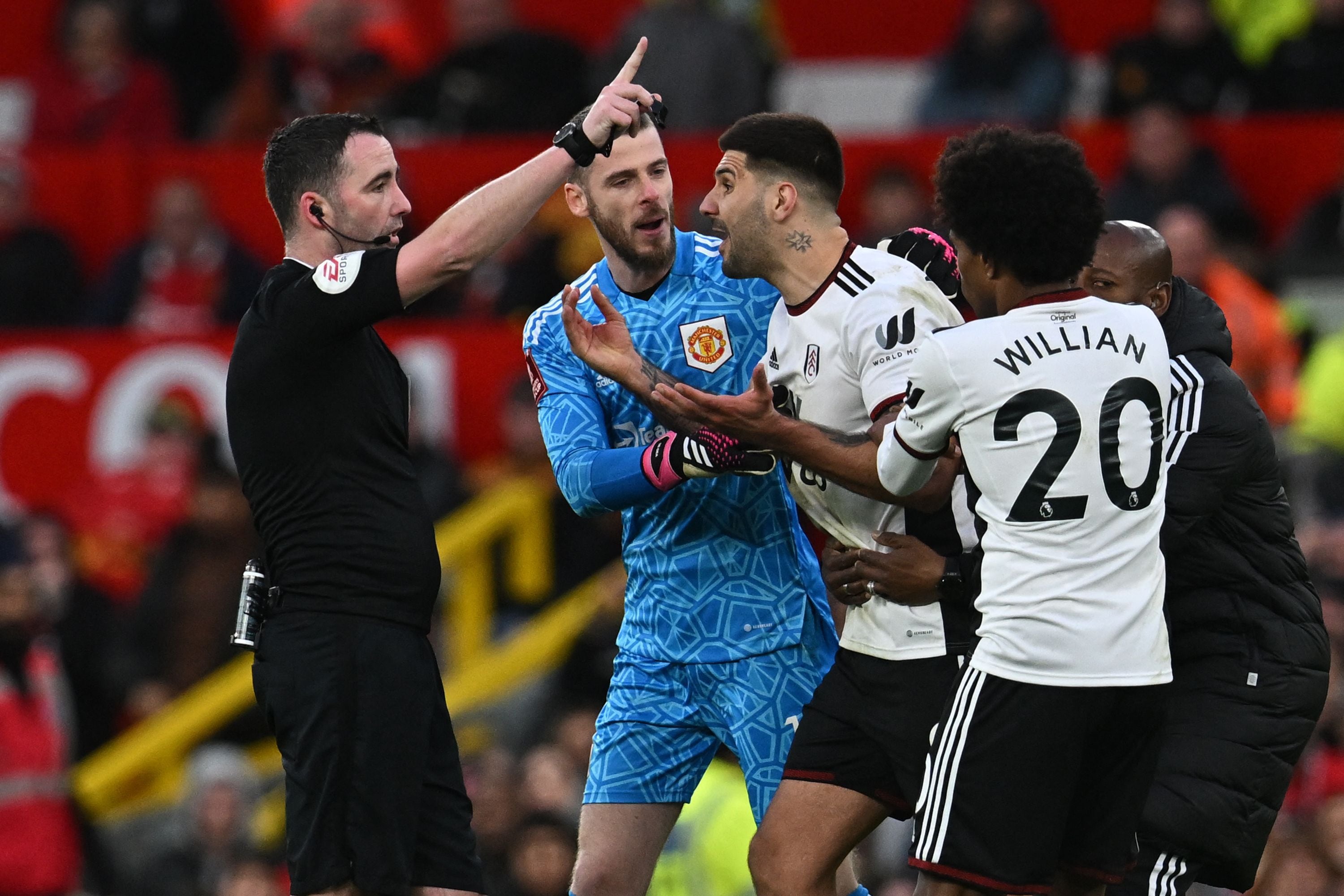 (FILES) In this file photo taken on March 19, 2023 Fulham's Serbian striker Aleksandar Mitrovic (C) is restrained by Manchester United's Spanish goalkeeper David de Gea (2L), Fulham's Brazilian midfielder Willian (2R) and Fulham's assistant coach Luis Boa Morte (R) after being shown a red card by English referee Chris Kavanagh (L) during the English FA Cup quarter-final football match between Manchester United and Fulham at Old Trafford in Manchester, north-west England. - Aleksandar Mitrovic has received an eight-match ban following his sending-off in the club's FA Cup tie against Manchester United, the Football Association has announced, April 4. (Photo by Paul ELLIS / AFP) / RESTRICTED TO EDITORIAL USE. No use with unauthorized audio, video, data, fixture lists, club/league logos or 'live' services. Online in-match use limited to 120 images. An additional 40 images may be used in extra time. No video emulation. Social media in-match use limited to 120 images. An additional 40 images may be used in extra time. No use in betting publications, games or single club/league/player publications. / 