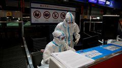 FILE PHOTO: Airline staff wear personal protective equipment (PPE) to protect against coronavirus disease (COVID-19) disease as they work at Beijing Capital International airport in Beijing, China March 13, 2022. REUTERS/Soe Zeya Tun/File Photo