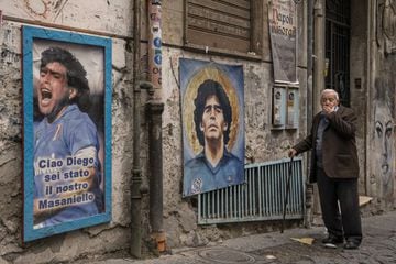 23 November 2021, Italy, Naples: A man walks past pictures honouring Argentine soccer legend Diego Maradona in the Spanish neighbourhood in Naples. A year after the soccer star died in a private residence north of Buenos Aires, Maradona is being commemora