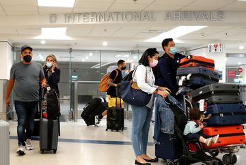 Travelers exit from the International arrivals door at Miami International Airport on September 20, 2021 in Miami, Florida. The U.S. government announced that it will ease airline restrictions on travel into the United States for people who have vaccinati